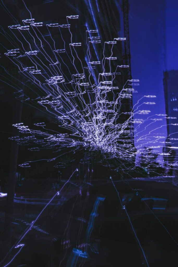 Abstract long exposure shot of blue light trails in a city at night, capturing dynamic energy.