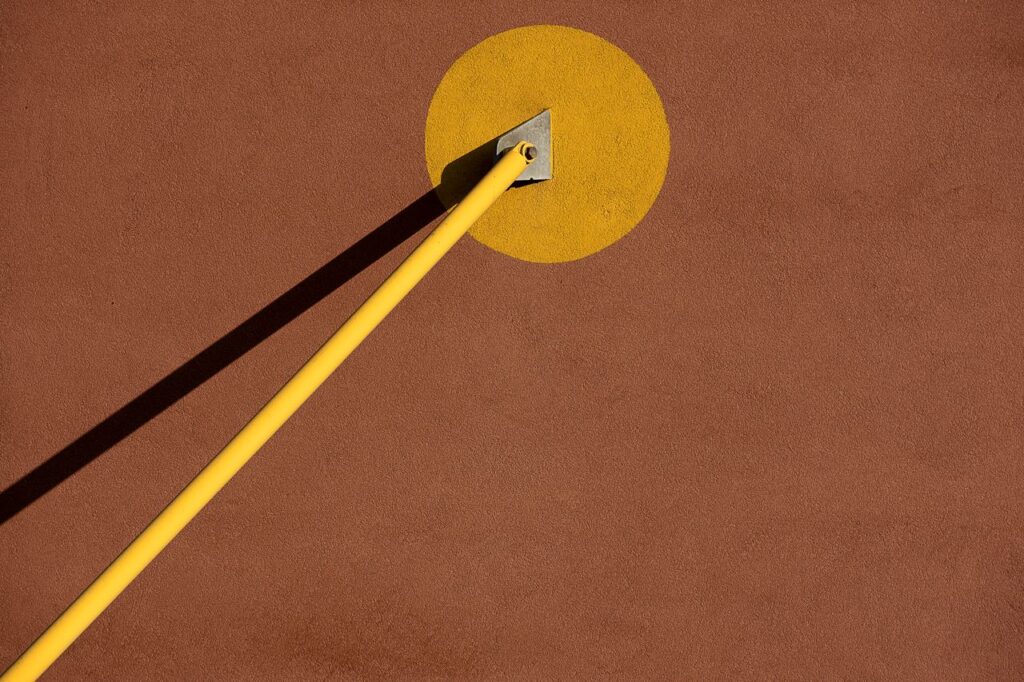Netzwerk Abstract composition with a yellow pole casting shadow on a brown surface, minimalistic design.